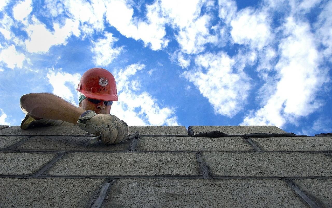 Ein Maurer baut eine Mauer
