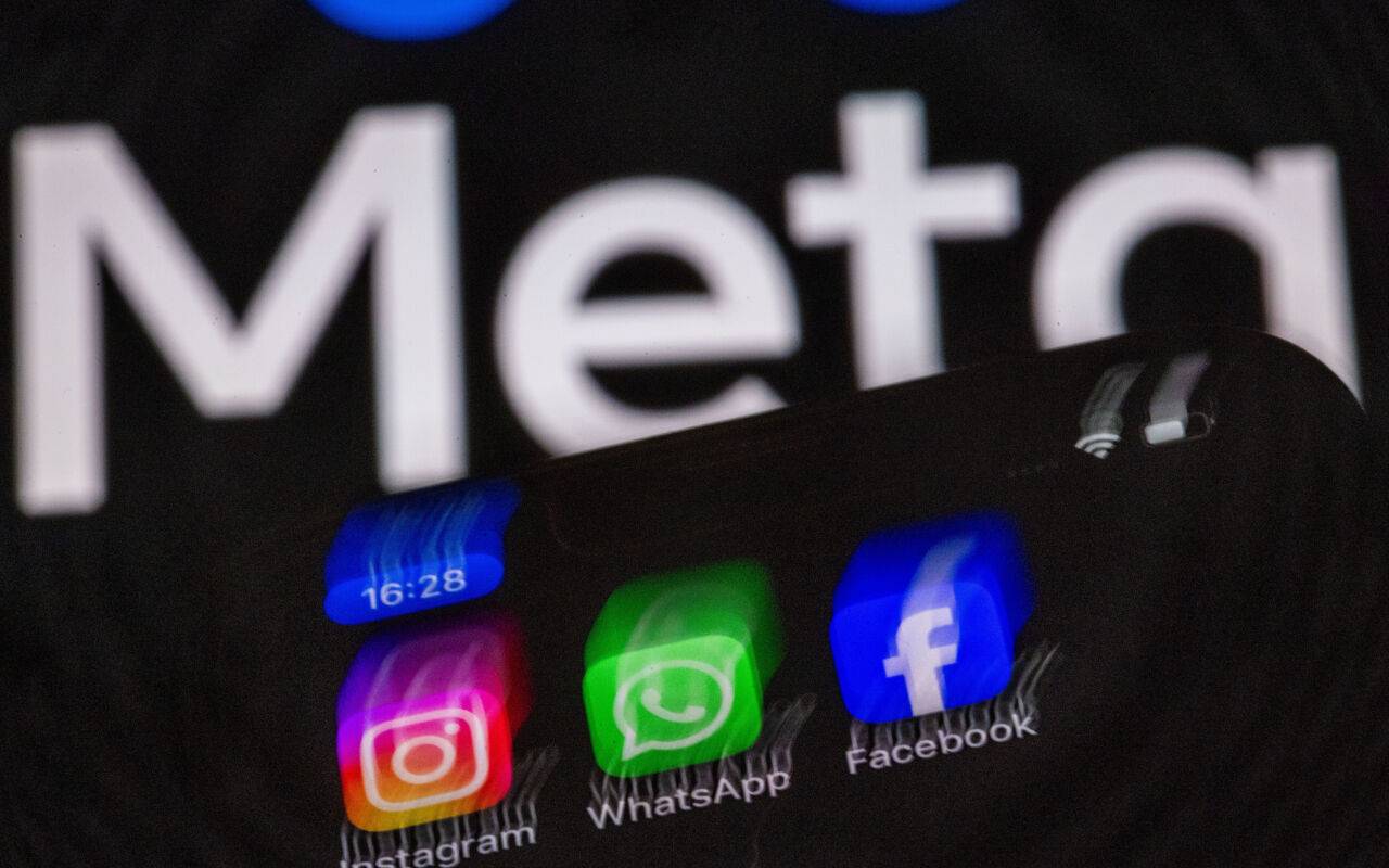 Die Apps Instagram, Facebook und WhatsApp sind auf dem Display eines Smartphones vor dem Logo des Internetkonzerns Meta zu sehen