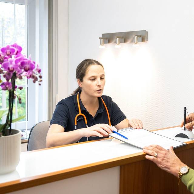 Eine Patientin wird von einer Sprechstundenhilfe beraten