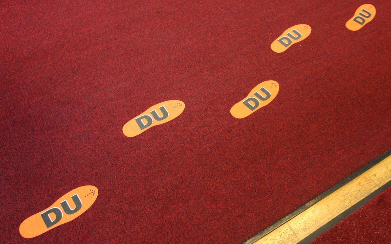 Aufgeklebte Fußstapfen mit der Aufschrift "DU"