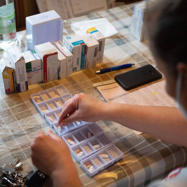Ambulante Pflegefachkraft sortiert Medikamente