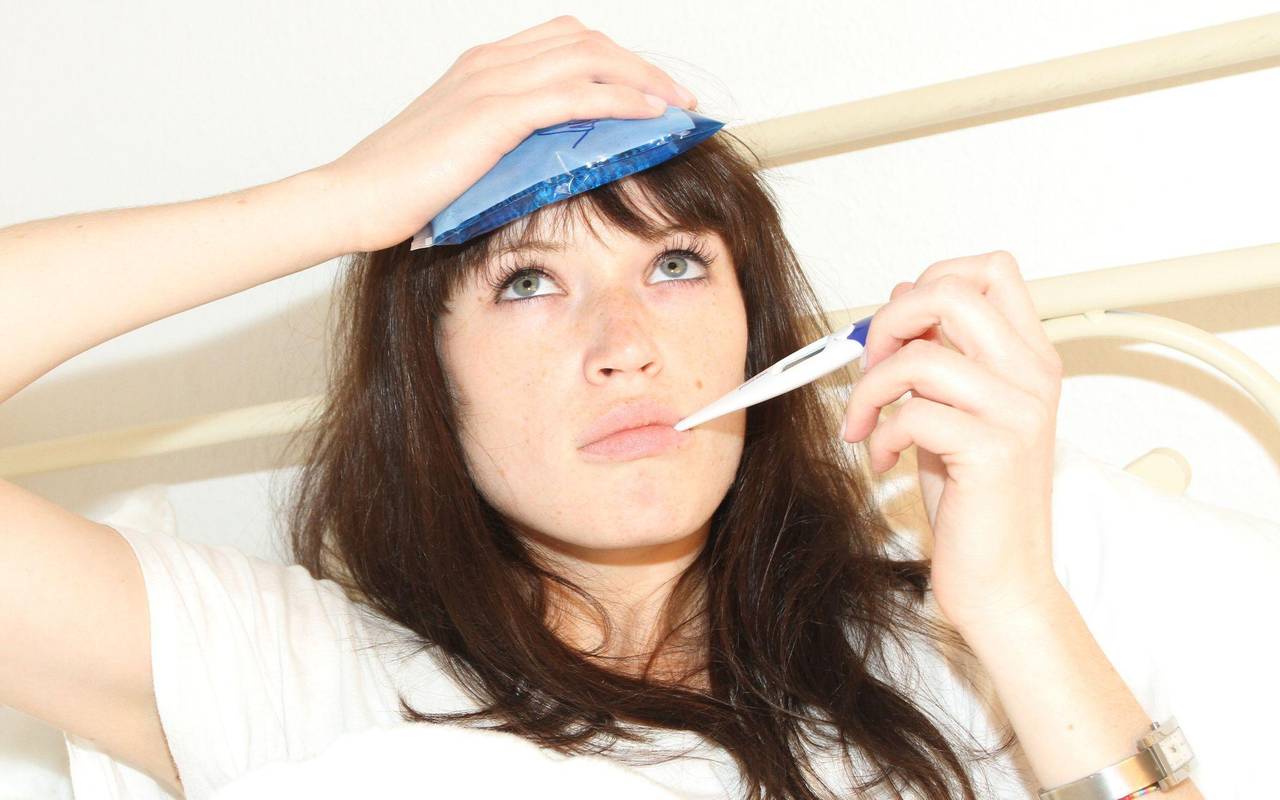 Frau liegt krank im Bett
