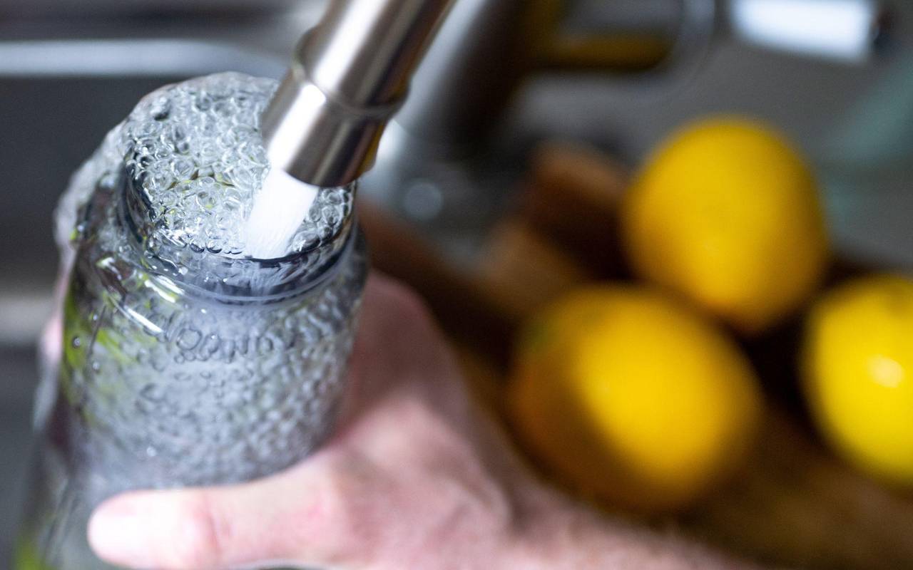 Eine person füllt ihre Trinkflasche auf