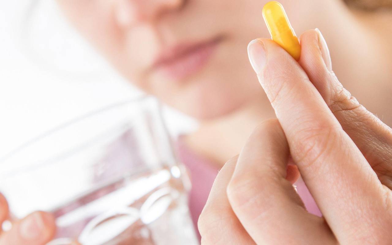 Frau hält eine Tablette in der Hand