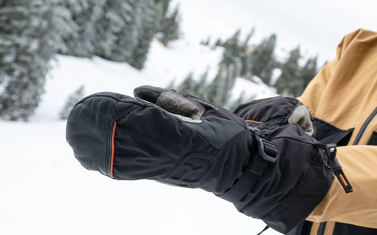 Skifahrer zieht Handschuhe an