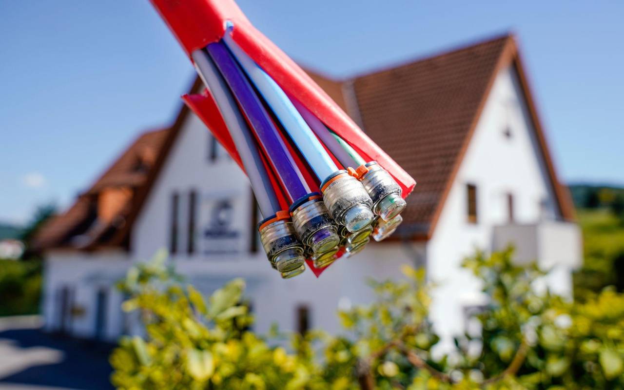 Bündel mit Umhüllungen für Glasfaserkabel vor einem Wohnhaus