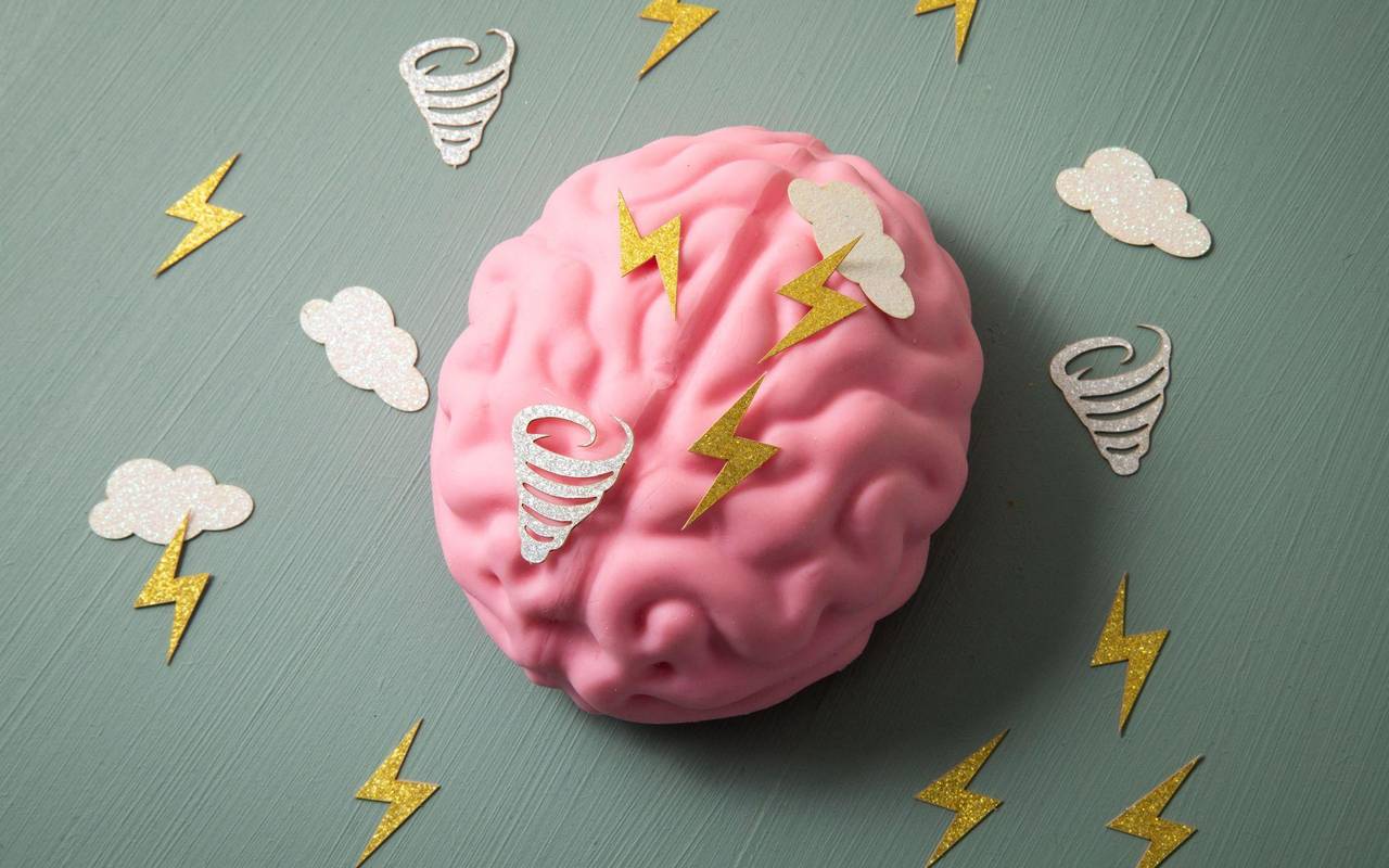 Symbole von Blitzen und Wirbelstürmen auf einem Gehirn-Modell