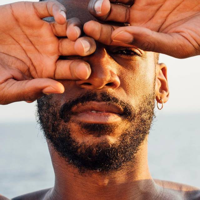 Ein Mann mittleren Alters hält die Hände vors Gesicht