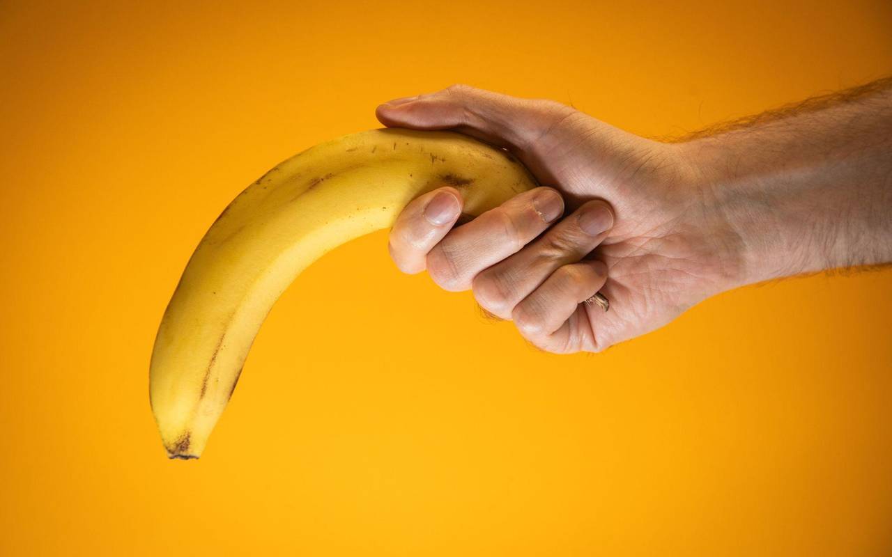 Eine Person hält eine Banane, die nach unten gerichtet ist