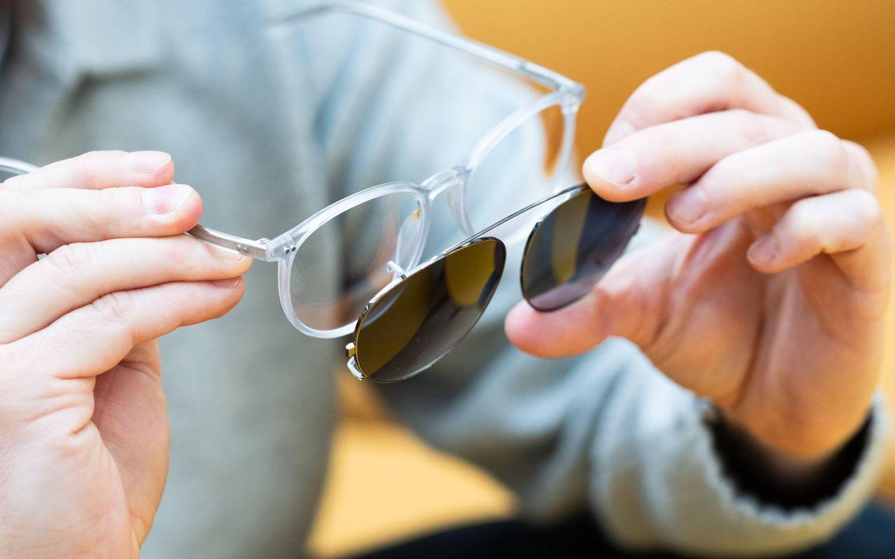 Mann befestigt Sonneclips an seiner Brille