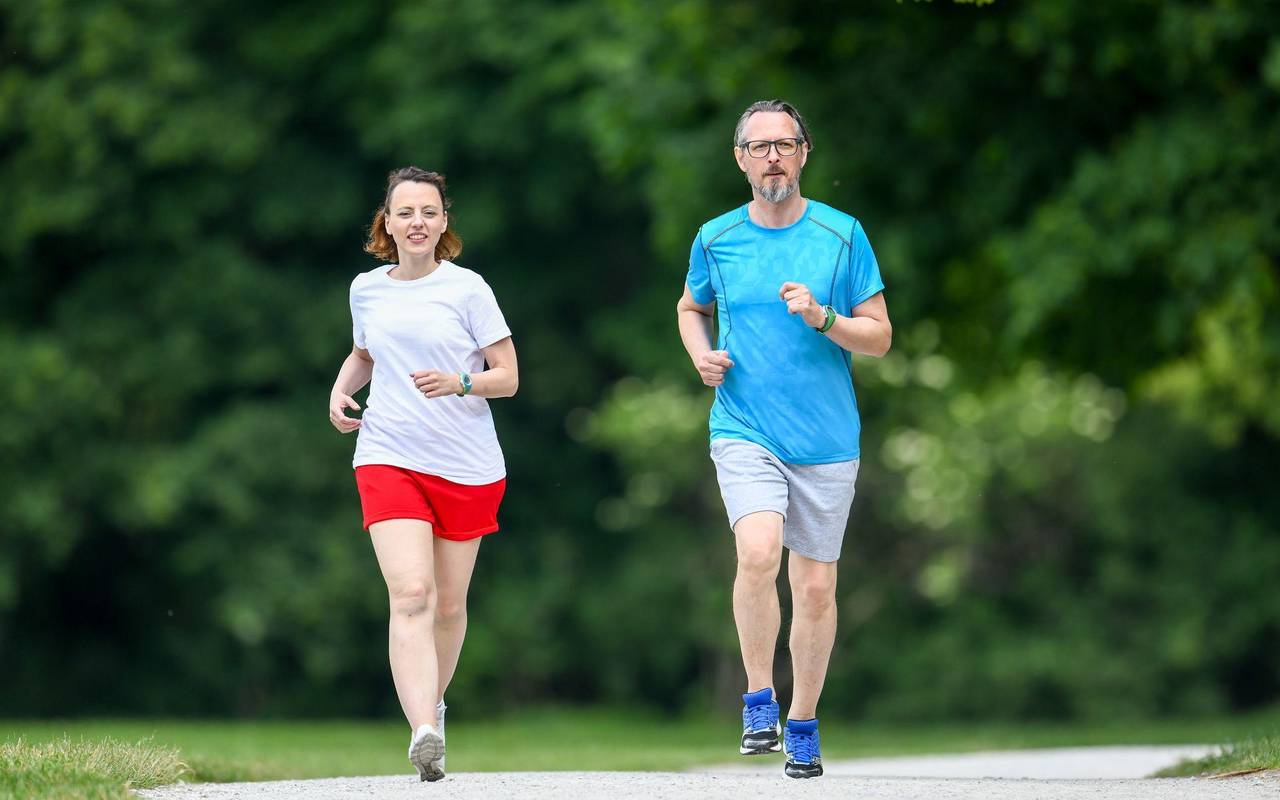 Ein Mann und eine Frau joggen gemeinsam im Park