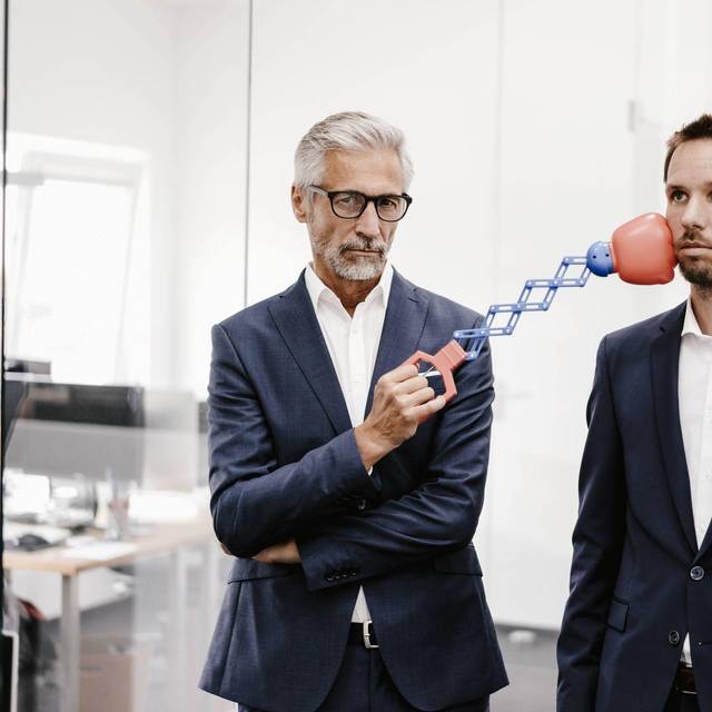 Ein Mann trfft einen Kollegen mit einem Boxspielzeug am Kinn