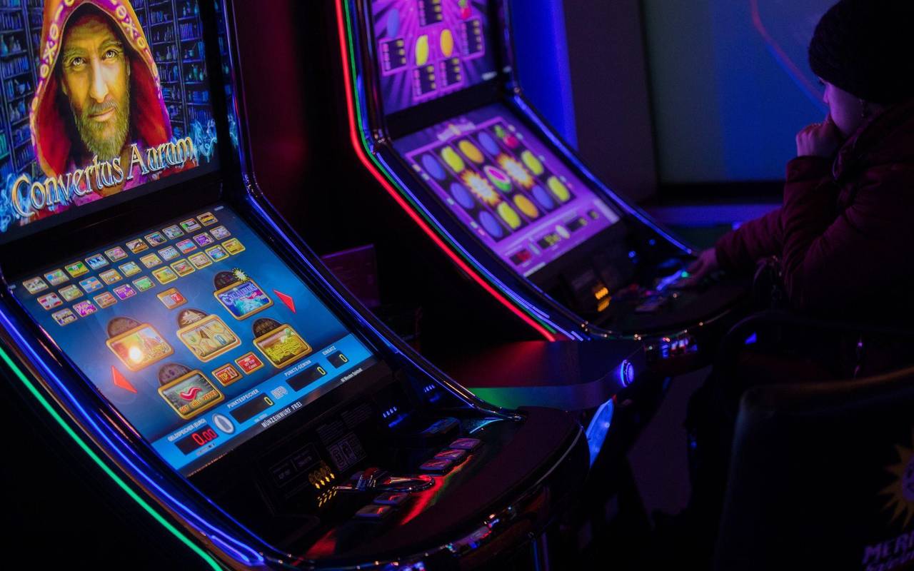 Eine Person sitzt an einem Spielautomaten