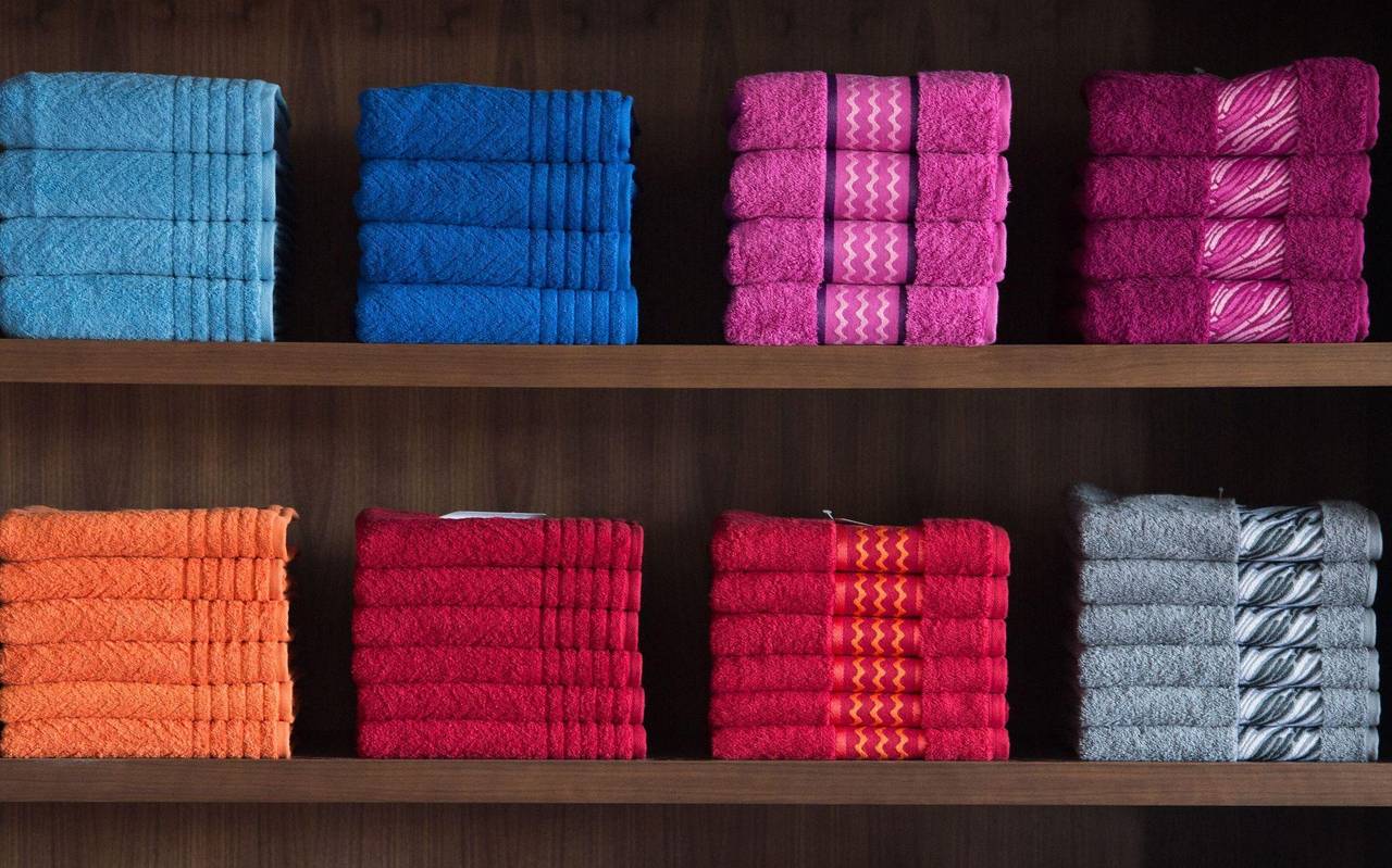 Nach Farben sortierte Handtücher in einem Regal