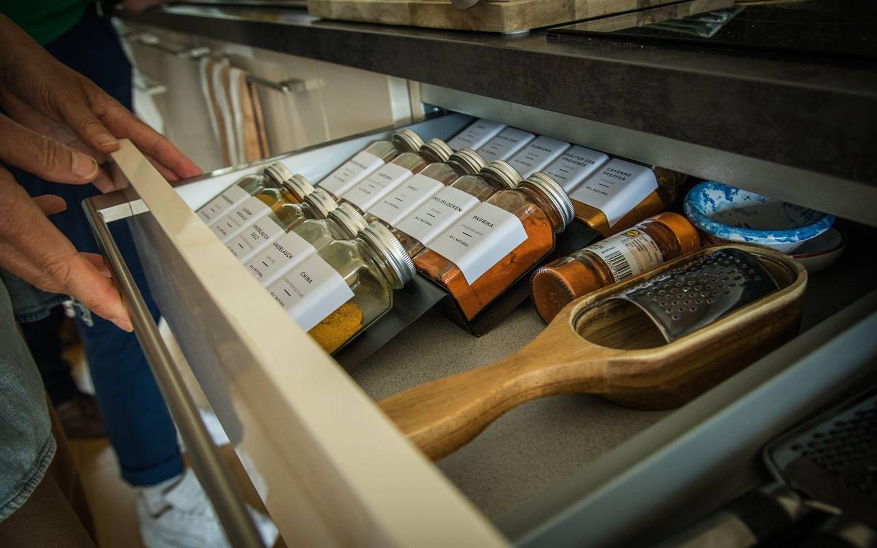 Eine Person öffnet eine Gewürzschublade in einer Küche