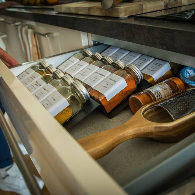 Eine Person öffnet eine Gewürzschublade in einer Küche