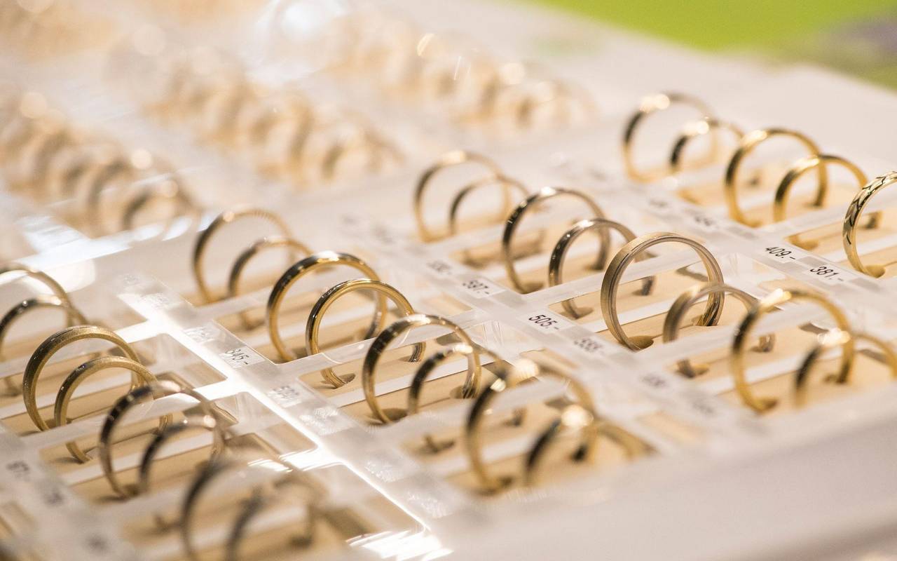 Eheringe liegen bei einer Hochzeitsmesse in einer Vitrine