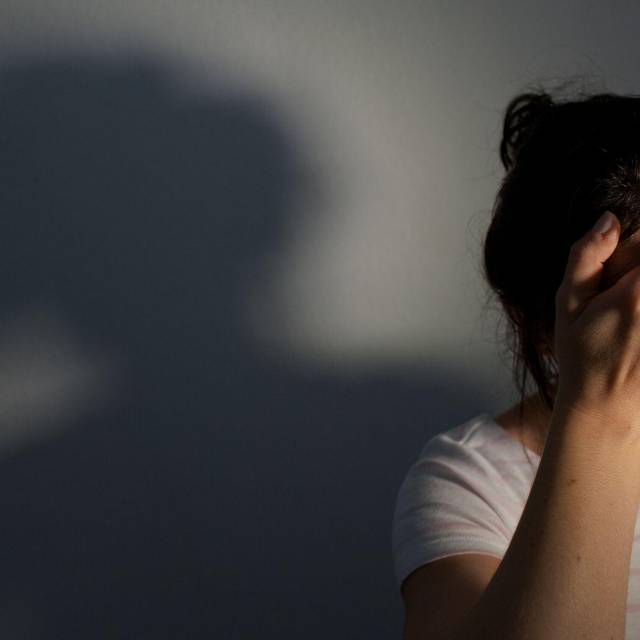 Frau fasst sich an die Stirn