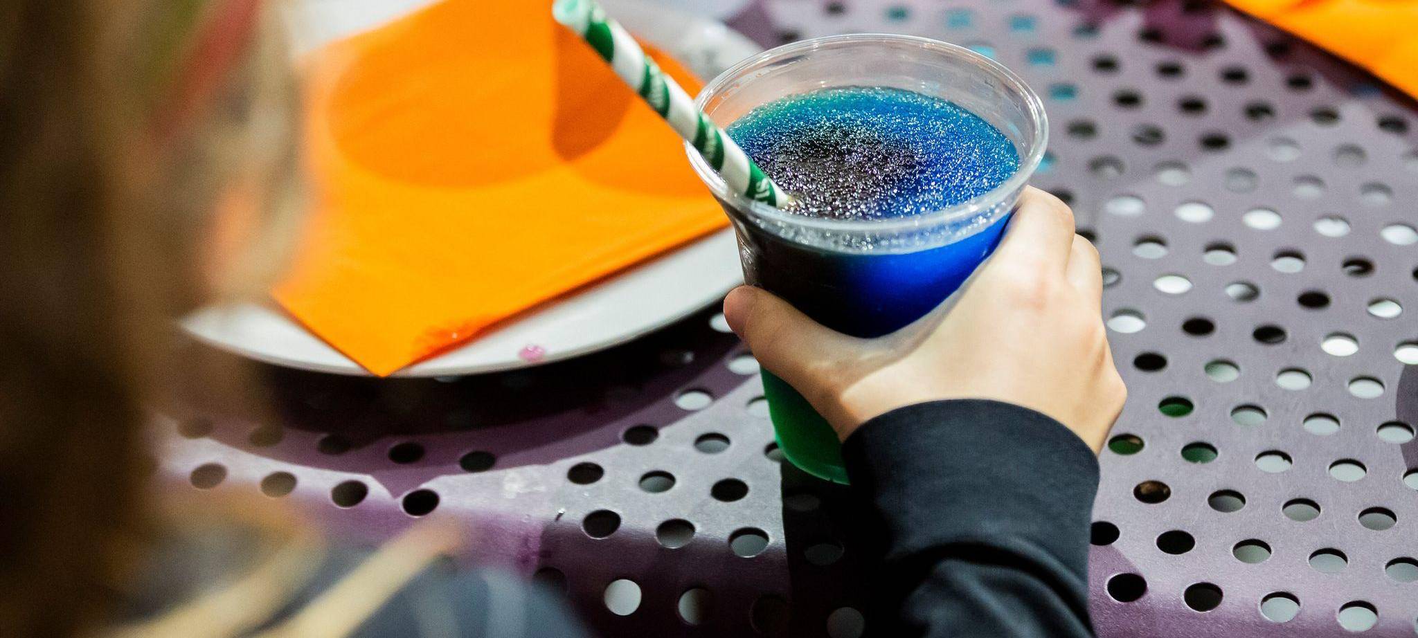 Kind trinkt ein Slush-Eis bei einem Kindergeburtstag
