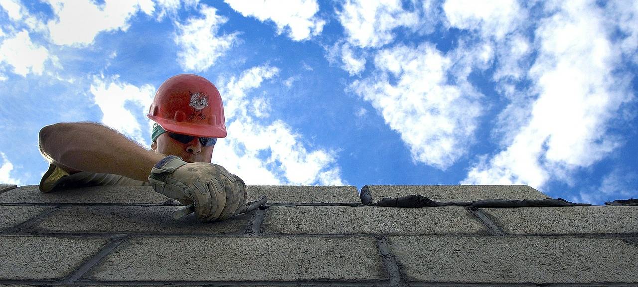 Ein Maurer baut eine Mauer