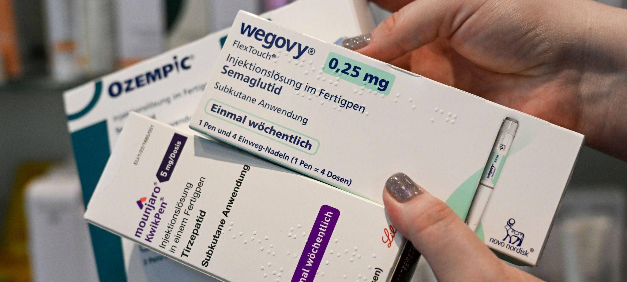 Eine Frau hält Abnehmspritzen verschiedener Marken in den Händen