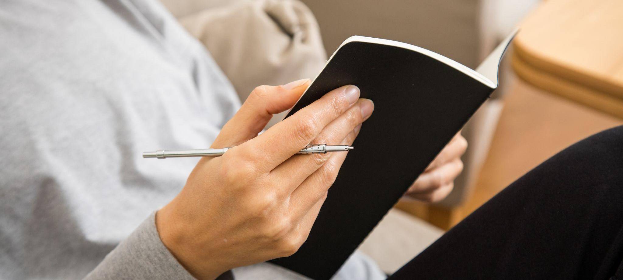 Eine Frau schreibt in ein Heft