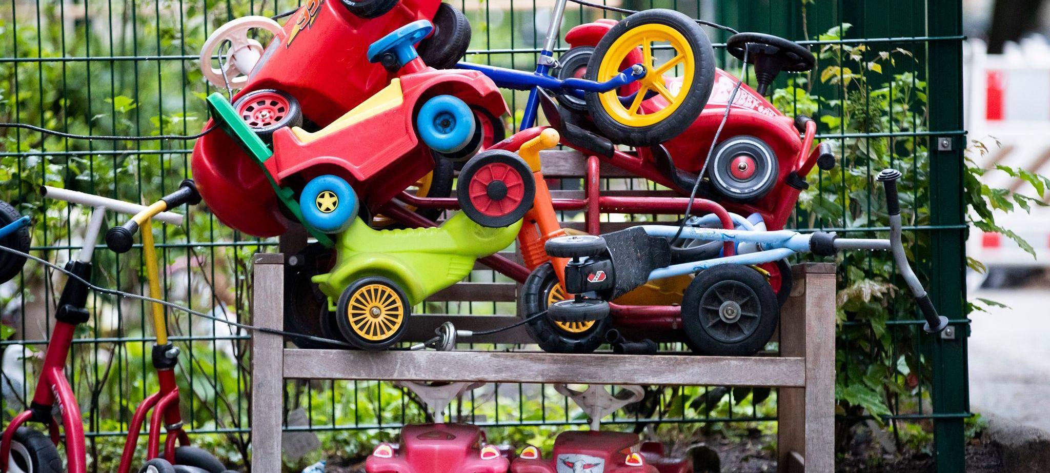 Spielautos für Kinder stehen vor einer Kita