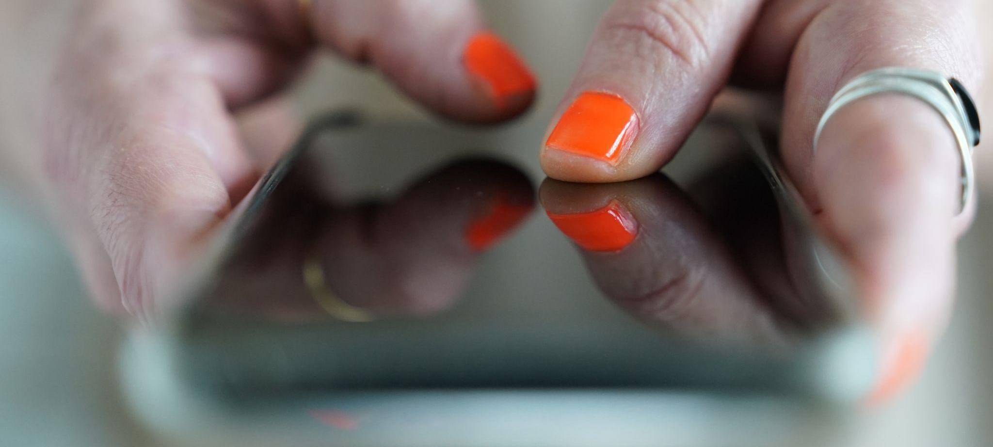 Eine Frau tippt auf einem Smartphone