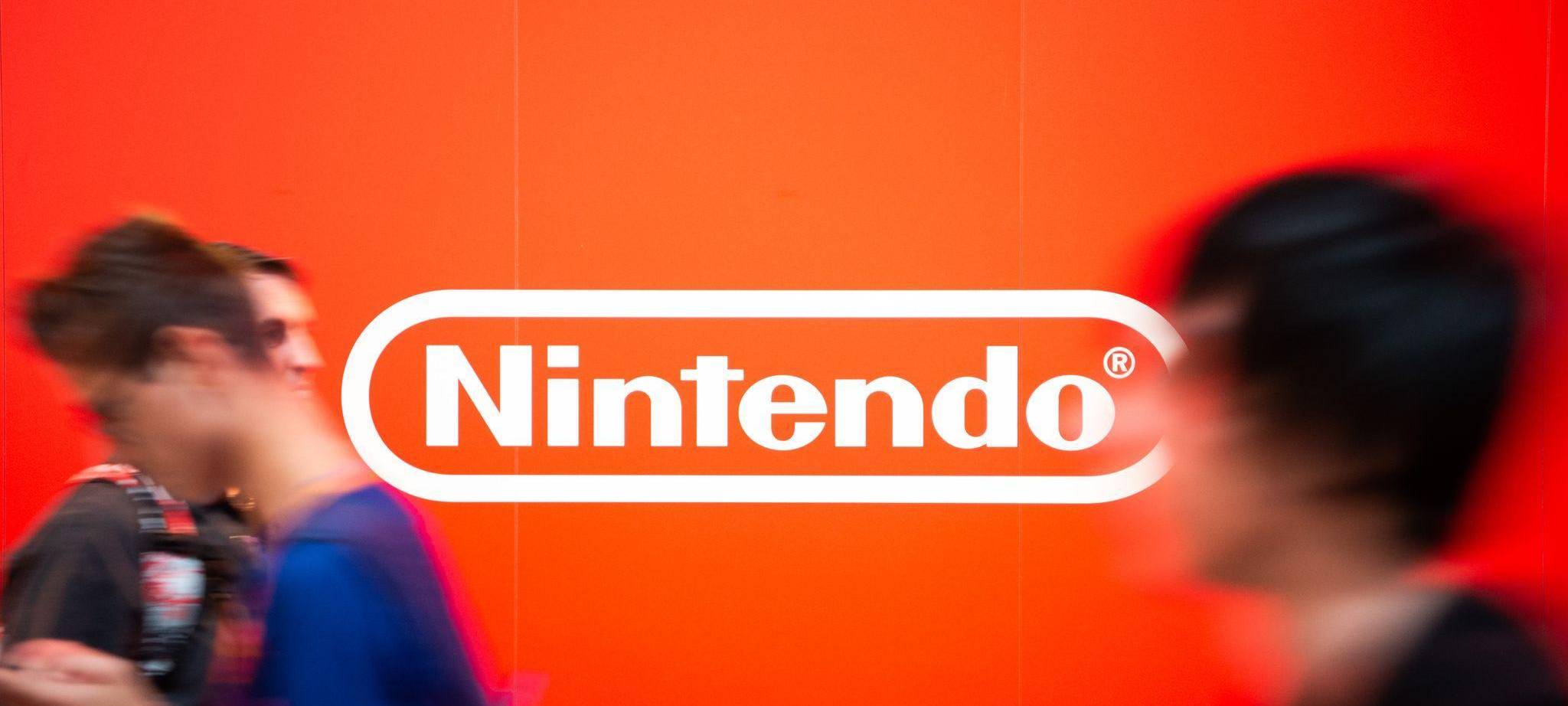 Besucher auf der Gamescom laufen an dem Nintendo-Logo vorbei