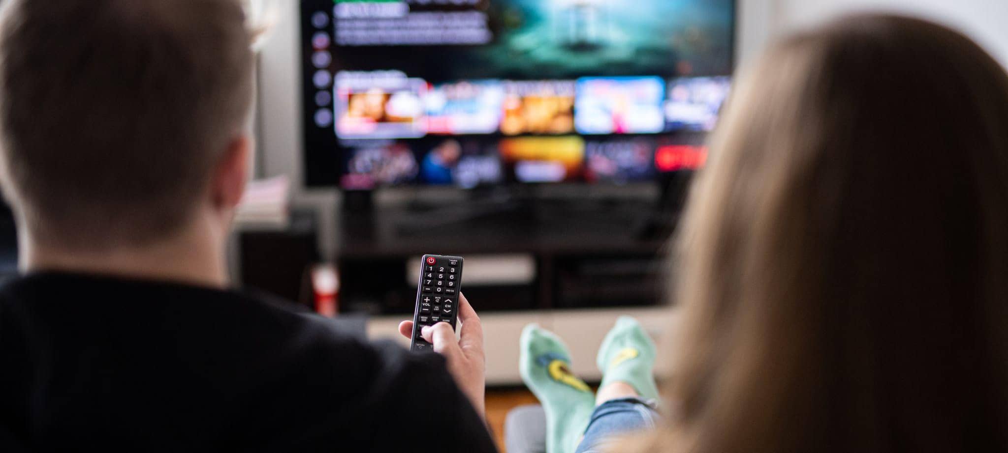 Ein Paar sitzt vor dem Fernseher,